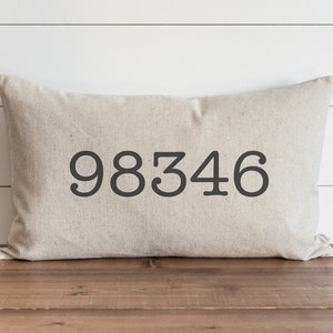 May include: A beige linen pillow with the number 98346 printed in black.