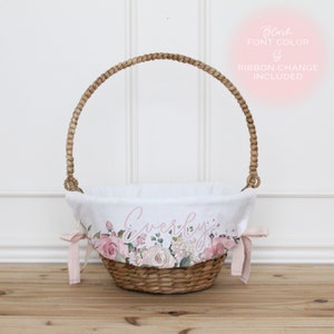May include: A white wicker basket with a pink floral fabric liner and a pink ribbon. The liner has the name "Everly" printed on it. The basket is perfect for Easter or a baby shower.