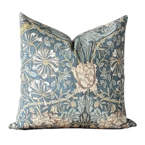 May include: A blue and green floral pillow with a repeating pattern of stylized flowers and leaves. The pillow is made of a soft, comfortable fabric and has a subtle sheen.