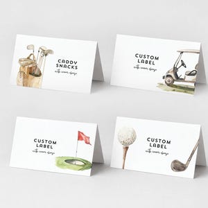 Könnte beinhalten: Vier weiße gefaltete Karten mit Aquarellillustrationen von Golfartikeln. Eine Karte trägt die Aufschrift "CADDY SNACKS" mit einer Golftasche und Schlägern. Andere Karten tragen die Aufschrift "CUSTOM LABEL" mit einem Golfwagen, einem Golfloch mit Fahne und einem Golfball auf einem Tee.