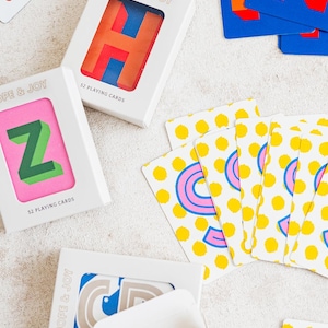 Custom playing cards with color and design options for the background, and personalized colors for letters.