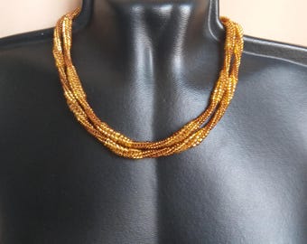 Lange spiraalvormige visgraatketting geweven met gouden kralen. Handgemaakte kralensieraden