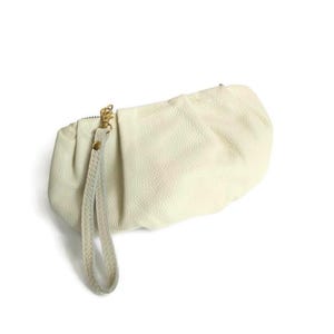 Bolso pequeño de piel blanca, estilo vintage italiano, con asa superior.