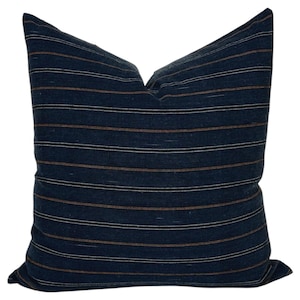 May include: A blue and brown striped throw pillow with a square shape.