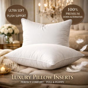 May include: Two white, fluffy pillows are stacked on a beige upholstered surface. The pillows have a smooth, soft texture and are labeled "Ultra Soft Plush Support" and "100% Premium Down Alternative". The text "Luxury Pillow Inserts" is at the bottom.