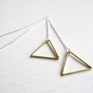 May include: A pair of gold triangle earrings with silver chain drop earrings. The earrings are simple and modern.