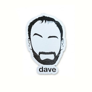 Op de afbeelding: Zwart-witte geborduurde patch van een mannengezicht met een baard en het woord "dave" eronder.