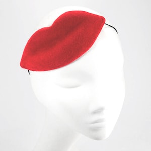 以下が含まれることがあります： 唇の形をした赤いフェルトのヘッドバンド