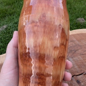 May include: A ceramic mug with a brown and orange glaze. The glaze has a streaky effect, creating a unique look. The mug has a white rim.