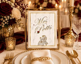 May include: A rectangular gold-framed table sign featuring the text Mrs. Potts in elegant gold script. The design includes a small red rose graphic and a faint illustration of two figures dancing, set against a white background with gold borders.