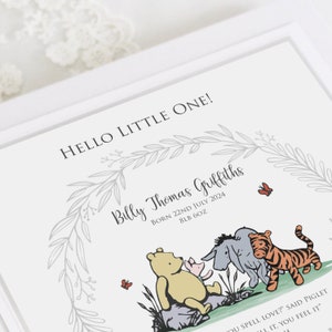 K&ouml;nnte beinhalten: Ein wei&szlig;er Geburtsanzeige-Druck mit dem Text HELLO LITTLE ONE!, Billy Thomas Griffiths, BORN 22ND JULY 2024, 8LB 6OZ und einem Zitat. Das Design enth&auml;lt einen grauen Blattkranz und Illustrationen der Figuren aus Winnie Puuh.