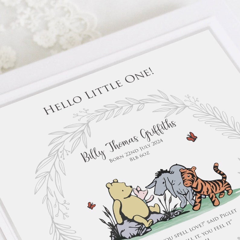 K&ouml;nnte beinhalten: Ein wei&szlig;er Geburtsanzeige-Druck mit dem Text HELLO LITTLE ONE!, Billy Thomas Griffiths, BORN 22ND JULY 2024, 8LB 6OZ und einem Zitat. Das Design enth&auml;lt einen grauen Blattkranz und Illustrationen der Figuren aus Winnie Puuh.