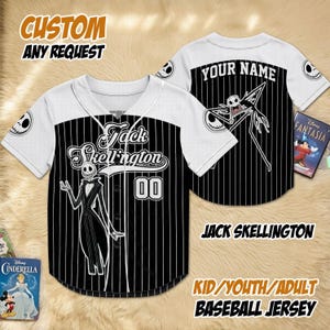 May include: A black and white baseball jersey with pinstripes, featuring Jack Skellington from The Nightmare Before Christmas. The jersey has the text "Jack Skellington" and "00" on the front, and "YOUR NAME" on the back. The sleeves are white.