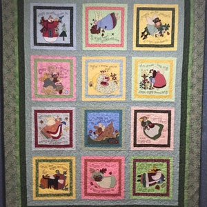 May include: A quilt with a green border and a light blue background. Each square features a different illustration of an angel with a quote about angels. The quotes include "Angels are the guardians of magic and miracles", "Mother is another word for angel", "Angels have a song to sing", "Art flourishes where angels sing", "My angels are very, very special", "Everything lovely is a prayer", "Never fear angels are here", "Thank you God you are with me", "I'm there now for you to see".