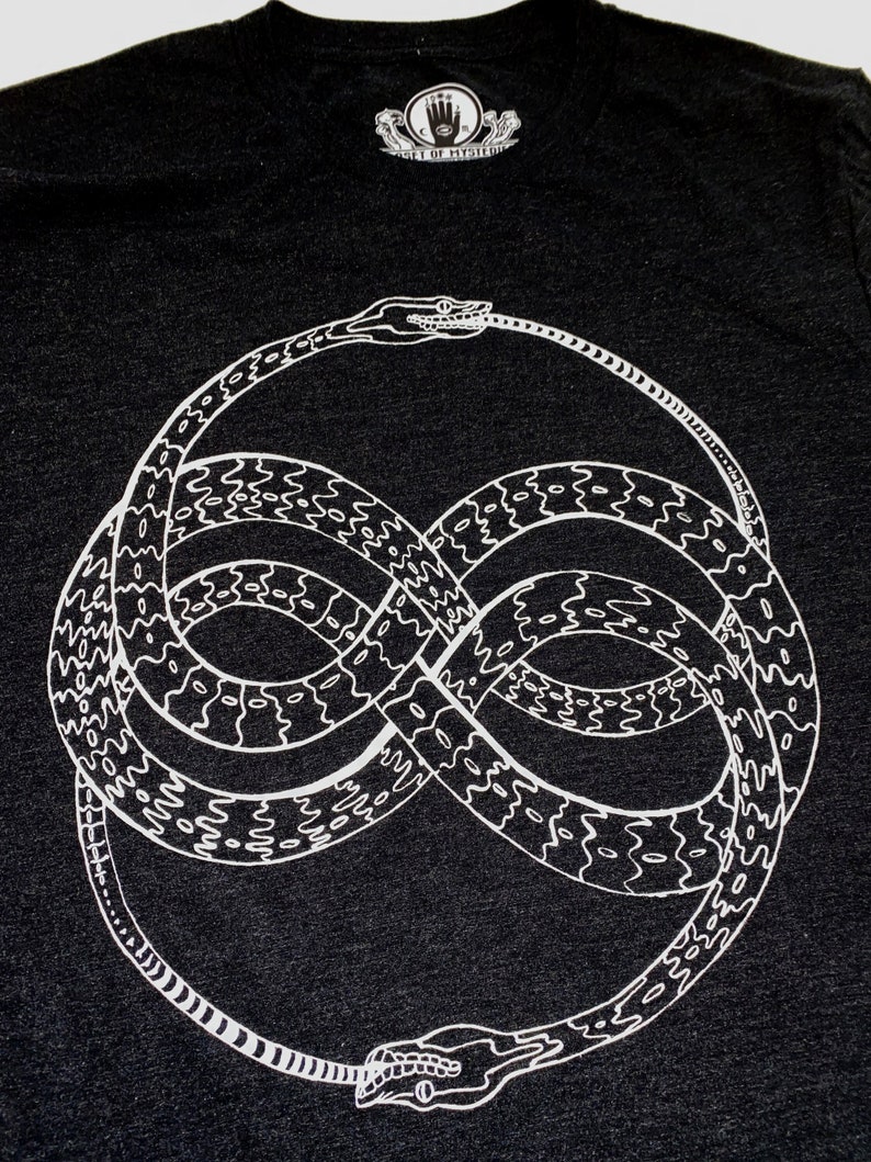 May include: A black t-shirt with a white graphic of two snakes intertwined in the shape of an infinity symbol. The text "Gift of Mystery" is printed on a small tag above the graphic.