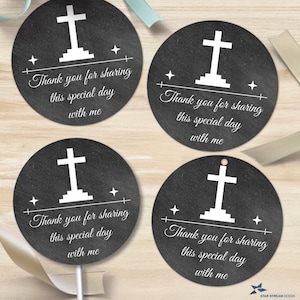 May include: Four round black and white favor tags with a white cross on a black background. The text on the tags reads "Thank you for sharing this special day with me".