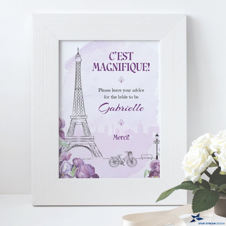 K&ouml;nnte beinhalten: Ein wei&szlig;er Rahmen mit einem lila und wei&szlig;en Aquarellhintergrund, der eine Schwarzwei&szlig;illustration des Eiffelturms zeigt. Der Text "C'EST MAGNIFIQUE!" ist in lila Farbe. Der Text "Please leave your advice for the bride-to-be Gabrielle Merci!" ist ebenfalls in lila Farbe.