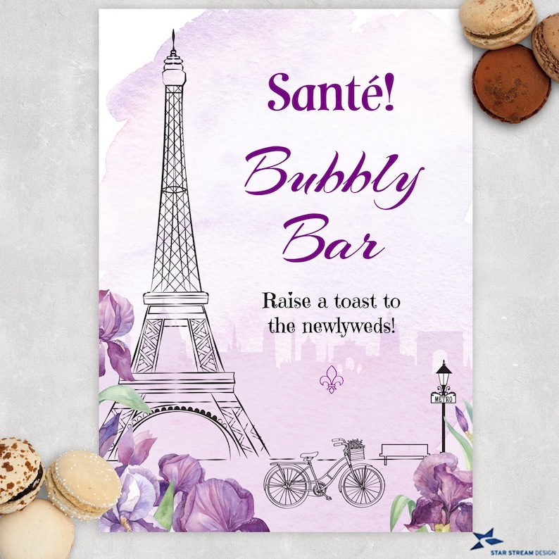 K&ouml;nnte beinhalten: Ein druckbares Schild mit einem violetten Aquarellhintergrund, das eine Schwarzwei&szlig;illustration des Eiffelturms, eines Fahrrads und lila Iris zeigt. Der Text auf dem Schild lautet "Sante! Bubbly Bar Raise a toast to the newlyweds!"