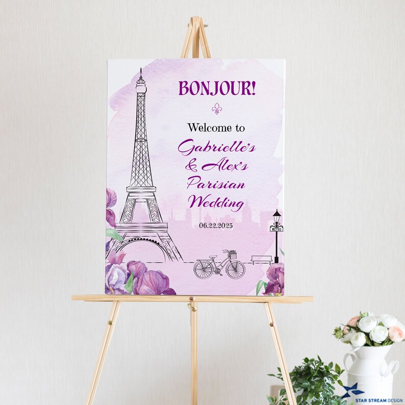 K&ouml;nnte beinhalten: Ein rosafarbenes und violettes Aquarell-Hochzeitschild mit einer Schwarzwei&szlig;illustration des Eiffelturms, eines Fahrrads und einer Stra&szlig;enlaterne. Der Text auf dem Schild lautet "Bonjour! Willkommen zur Pariser Hochzeit von Gabrielle und Alex 06.22.2025".