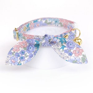 Peut inclure: Un collier de chat floral blanc, bleu et rose avec une clochette et un nœud papillon.