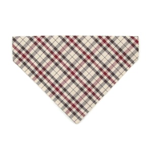 May include: A beige, red, and black plaid dog bandana. The bandana is triangular in shape and has a stitched edge.