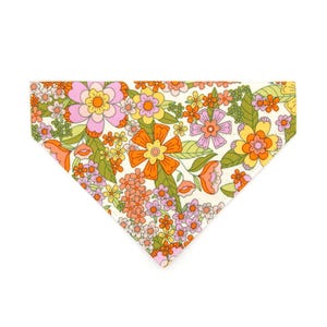May include: A white bandana with a retro floral print featuring orange, pink and yellow flowers. The bandana has a triangular shape and is perfect for adding a touch of vintage style to any outfit.