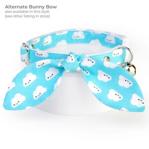 May include: A light blue cat collar with a bunny bow, featuring a pattern of smiling white clouds. The collar has a silver-colored metal buckle and a small bell. Text on the image reads "Alternate Bunny Bow, also available in this style (see other listing in store)".