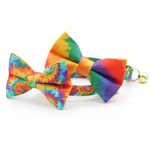 Może przedstawiać: Kołnierz dla kota z wzorem tie-dye z dzwoneczkiem i dopasowaną muszką. Kołnierz jest wykonany z miękkiego, wygodnego materiału i jest regulowany, aby pasował do większości kot&oacute;w.