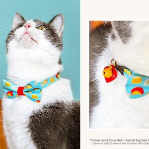 May include: A white and gray cat wearing a blue and red bow tie with a cheese pattern. The bow tie has a red bell attached to it. *Yellow Solid Color Bell + Red ID Tag Sold Separately (Silver or Gold Standard Bell Included with Collar Purchase)