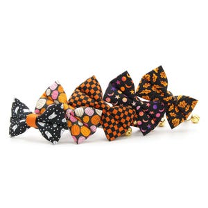 Peut inclure: Cinq n&oelig;uds papillon sur le th&egrave;me d'Halloween pour animaux de compagnie. Les n&oelig;uds papillon sont en tissu avec diff&eacute;rents motifs, notamment des citrouilles, des fant&ocirc;mes et des &eacute;toiles. Chaque n&oelig;ud papillon est dot&eacute; d'une clochette.