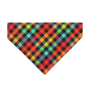 Puede incluir: Un pañuelo triangular para mascotas con un vibrante patrón de cuadros diagonales multicolor. La tela muestra una cuadrícula repetitiva de cuadrados en tonos rojo, naranja, amarillo, verde lima, azul cerceta y negro en disposición geométrica.