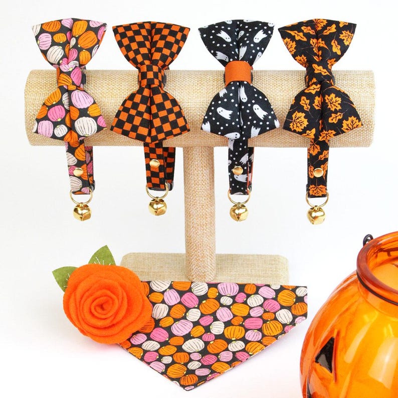 Peut inclure: Quatre colliers pour chat sur le th&egrave;me d'Halloween avec n&oelig;uds papillon et cloches. Les colliers pr&eacute;sentent diff&eacute;rents motifs, notamment des citrouilles, des fant&ocirc;mes et des motifs &agrave; carreaux. Un bandana &agrave; motif de citrouille rose et orange est &eacute;galement pr&eacute;sent&eacute;.