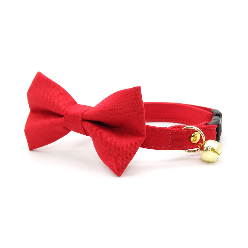 May include: Red cat collar with a matching bow tie and a gold bell.