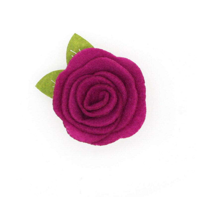 May include: A single, magenta felt rose with two green felt leaves.