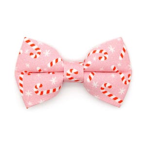 May include: Pink bow tie with a white and red candy cane pattern.