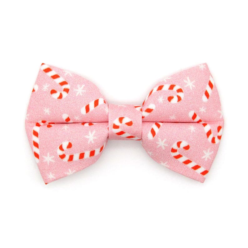 May include: Pink bow tie with a white and red candy cane pattern.