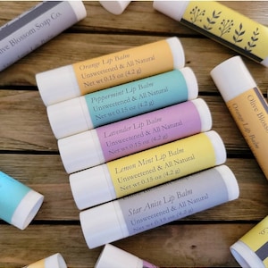 May include: A selection of lip balms in white tubes with labels in various colours. Flavours include orange, peppermint, lavender, lemon mint, and star anise. Each balm is labelled "Unsweetened & All Natural" and weighs 4.2 g.