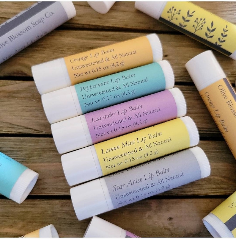 May include: A selection of lip balms in white tubes with labels in various colours. Flavours include orange, peppermint, lavender, lemon mint, and star anise. Each balm is labelled "Unsweetened & All Natural" and weighs 4.2 g.
