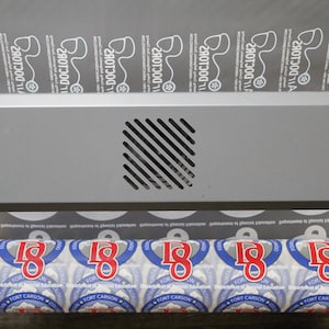 A roll of DTF prints in production, showing multiple logos for different businesses, including '11 Doctors' and 'Fort Carson Department of Special Education.' The sheet is being processed through a printer.