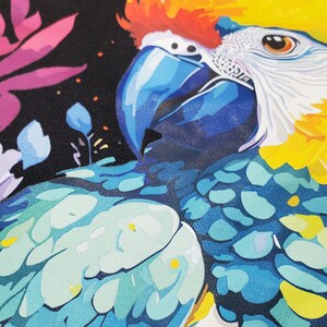 A vibrant close-up of a UV DTF or DTF print featuring a colorful parrot with blue, yellow, and red feathers against a dark floral background. The print has fine details and a smooth texture.