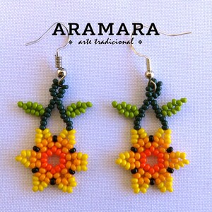 May include: A pair of beaded earrings featuring a yellow, orange, and red flower with green leaves. The earrings are made with small beads and have silver hooks.
