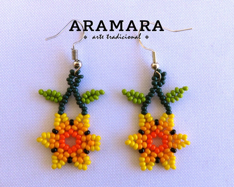 May include: A pair of beaded earrings featuring a yellow, orange, and red flower with green leaves. The earrings are made with small beads and have silver hooks.
