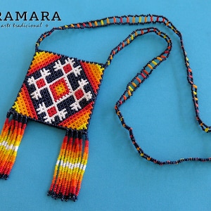 May include: A colorful beaded necklace with a square pendant featuring a geometric pattern in red, orange, yellow, white, and blue. The pendant has fringe on the bottom.