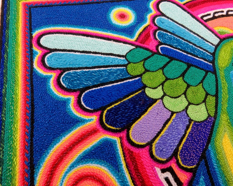 May include: A colourful embroidered artwork depicting a bird with vibrant blue, green, purple, and pink feathers. The background is a dark blue with a yellow sun.