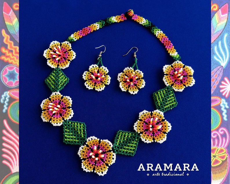 May include: A beaded necklace and earrings set featuring colorful flower designs. The necklace has five flowers with green leaves in between. The earrings are a matching pair of flowers. The set is made with small, colorful beads and has a white background.