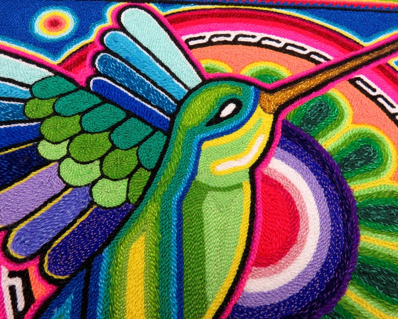 May include: A colourful embroidered hummingbird with green, blue, yellow and pink details. The hummingbird is flying with its wings spread out. The background is a vibrant blue with a pink and yellow sun.