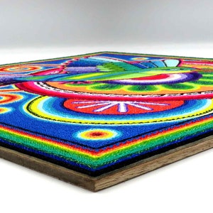 May include: A colourful hummingbird artwork made with tiny beads, framed in wood. The hummingbird is depicted in flight with its wings spread, surrounded by a vibrant circular design.