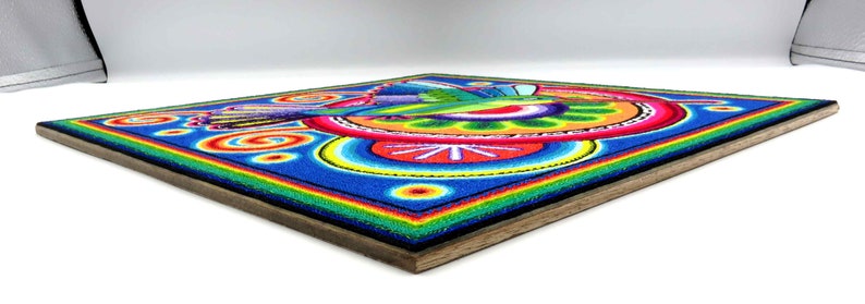 May include: A colourful hummingbird artwork made with tiny beads, framed in wood. The hummingbird is depicted in flight with its wings spread, surrounded by a vibrant circular design.