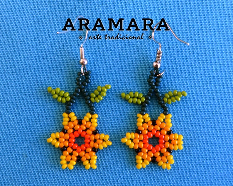 May include: A pair of beaded earrings featuring a flower design with yellow, orange, and green beads. The earrings are made with traditional techniques and have silver hooks.