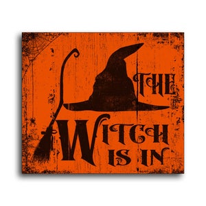May include: Orange wooden sign with a distressed look. The sign features a black silhouette of a witch's hat and broom with the text "The Witch is In".